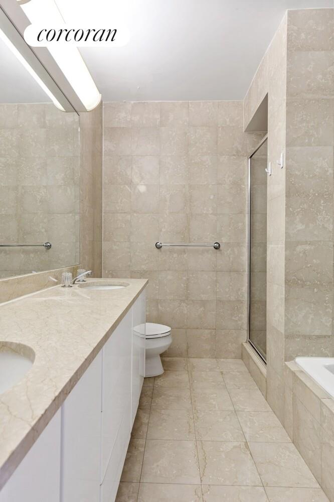 200 East 69th Street, Unit 21A Manhattan, NY 10021 - Photo 5 of 12 a bathroom with a granite countertop sink a toilet and shower