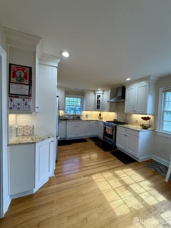 a large kitchen with stainless steel appliances kitchen island granite countertop a sink and cabinets