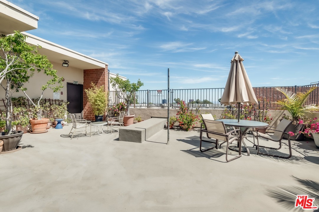 11750 Sunset Boulevard, Unit 123 Los Angeles, CA 90049 - Photo 23 of 31 a view of a patio with a table and chairs and potted plants