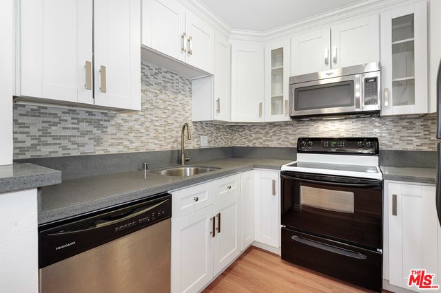 a kitchen with stainless steel appliances white cabinets and a granite counter tops