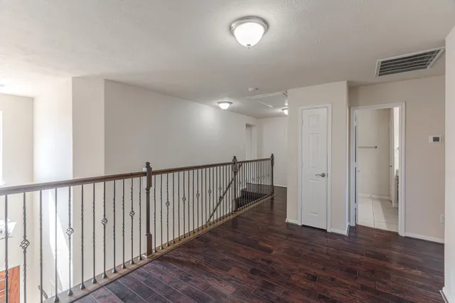 a view of a hallway with wooden floor