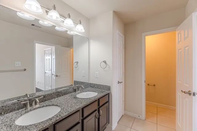 a bathroom with a granite countertop sink and a mirror