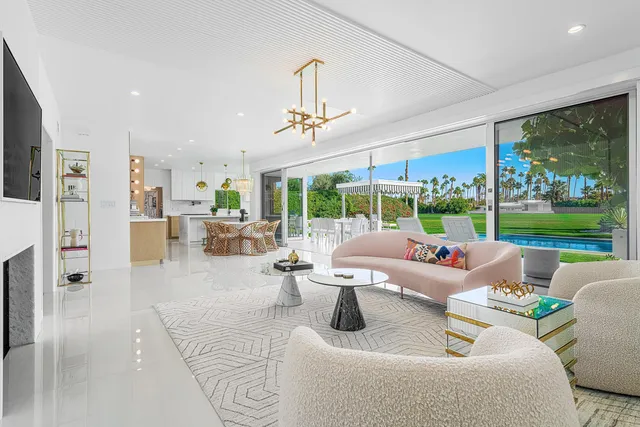 a living room with patio furniture and a large window