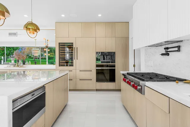 a kitchen with stainless steel appliances granite countertop a stove a sink and a refrigerator