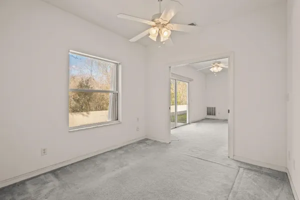 an empty room with a window and a fan