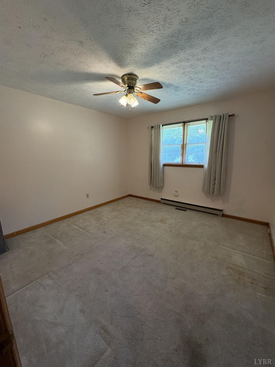 1796 Owens Mill Road Gretna, VA 24557 - Photo 13 of 20 an empty room with windows and fan