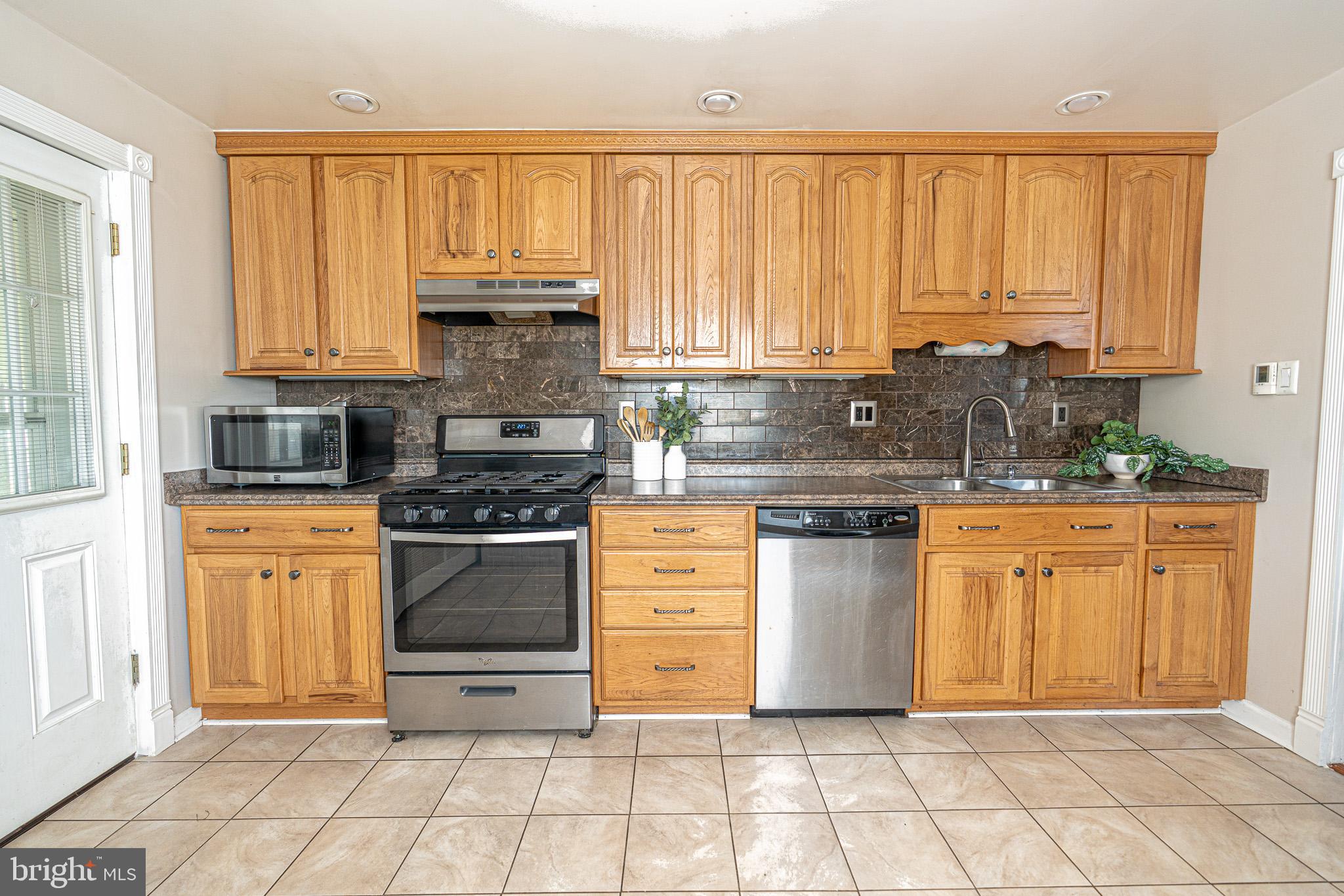 29 Sollers Point Road Baltimore, MD 21222 - Photo 8 of 29 a kitchen with stainless steel appliances granite countertop a stove a sink and white cabinets