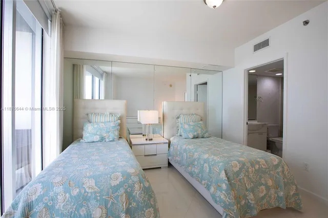 a bedroom with a large bed and a lamp