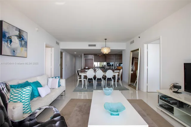 a living room with furniture and a dining table with wooden floor