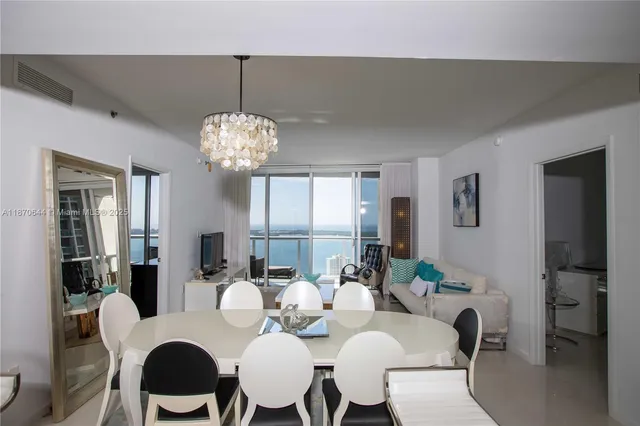 a dining room with furniture a chandelier and window