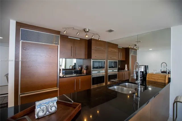 a kitchen with granite countertop a refrigerator stove and sink