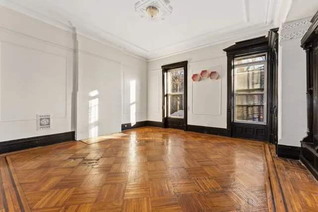 an empty room with a fireplace and windows