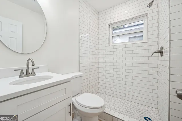 a bathroom with a toilet a sink a mirror and vanity