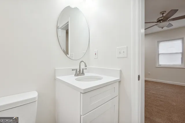 a bathroom with a toilet sink and mirror