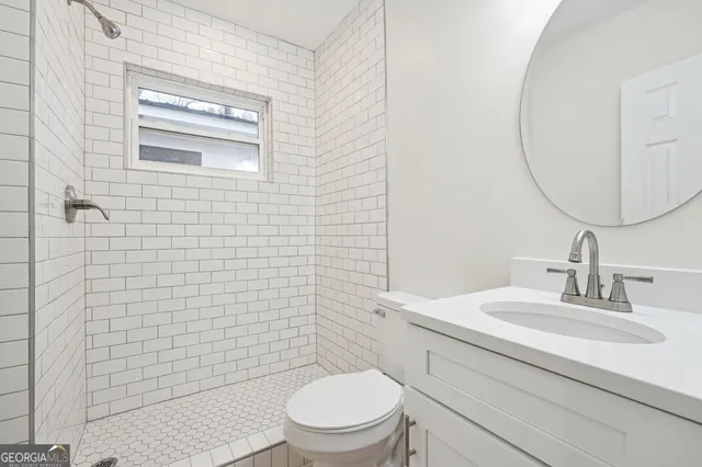 a bathroom with a toilet a sink and mirror