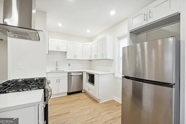 a kitchen with granite countertop a refrigerator stove and sink