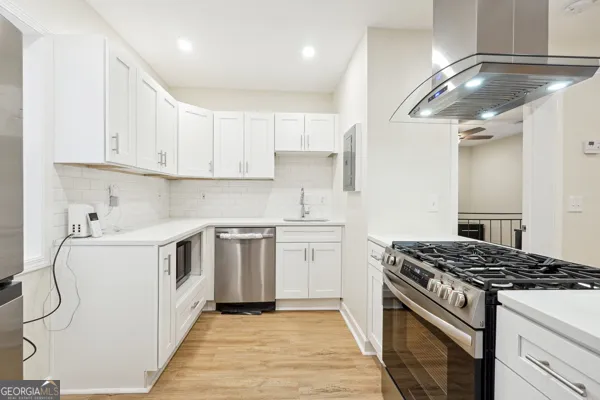a kitchen with granite countertop a sink stove and cabinets