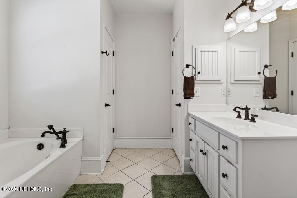 45107 South Booth Street Callahan, FL 32011 - Photo 34 of 68 a bathroom with a tub sink and mirror