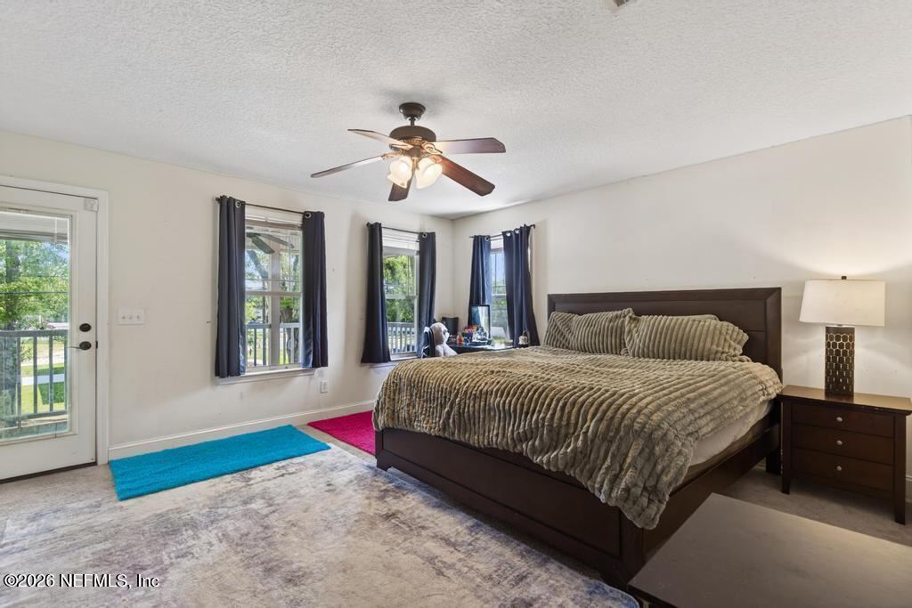 45107 South Booth Street Callahan, FL 32011 - Photo 38 of 68 a bedroom with a large bed and a chandelier fan