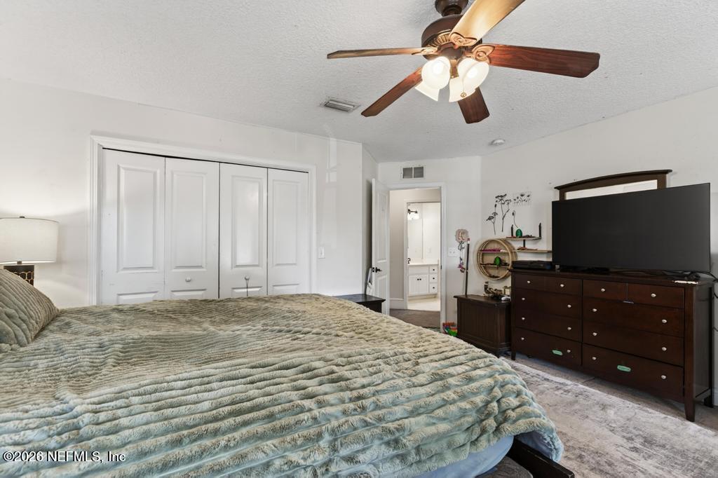 45107 South Booth Street Callahan, FL 32011 - Photo 40 of 68 a bedroom with a bed and a flat tv screen on dresser