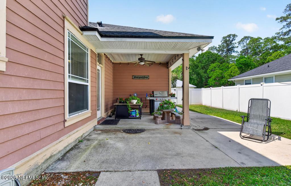 45107 South Booth Street Callahan, FL 32011 - Photo 53 of 68 a view of a patio with table and chairs potted plants with wooden fence