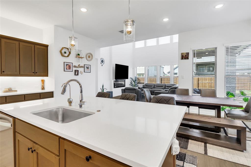 1241 Lupine Road Prosper, TX 75078 - Photo 12 of 38 Kitchen island featuring a stainless steel sink and a gooseneck faucet