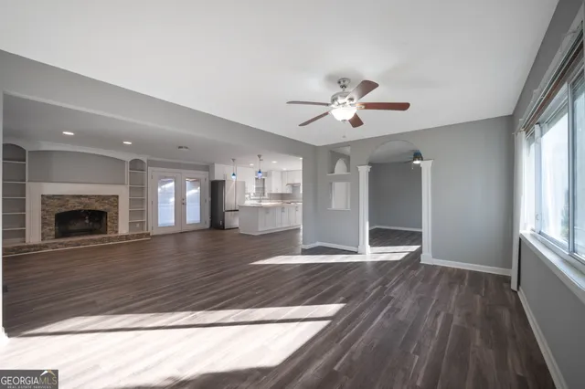 a view of an empty room with window and wooden floor