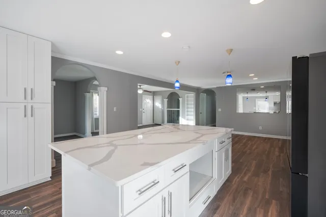a view of kitchen island a sink and wooden floor