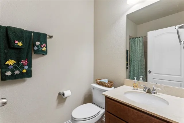 a bathroom with a sink a toilet and a mirror