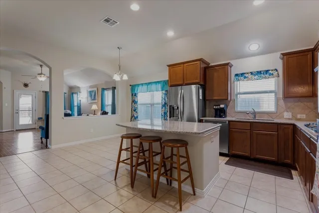 a kitchen with stainless steel appliances granite countertop a sink and a refrigerator
