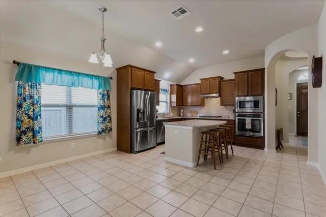 a kitchen with stainless steel appliances a refrigerator sink and microwave