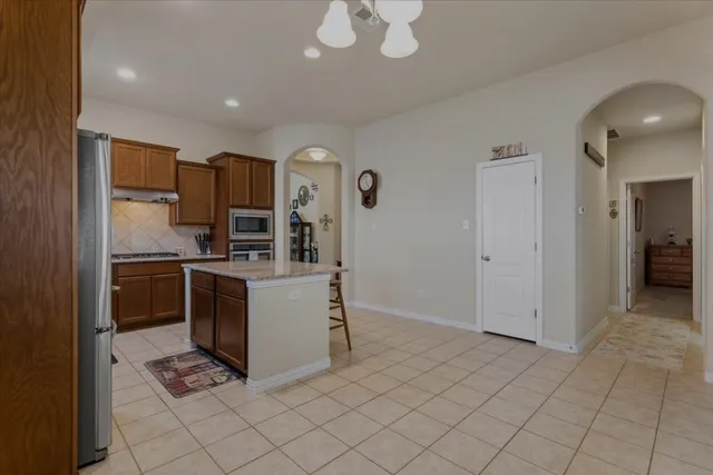 a kitchen with stainless steel appliances granite countertop a refrigerator and a sink