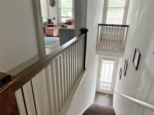 a view of staircase with wooden floor and fan