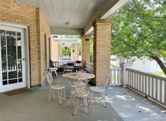 a view of a patio with table and chairs and floor to ceiling window
