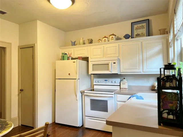 a kitchen with a refrigerator and a stove top oven