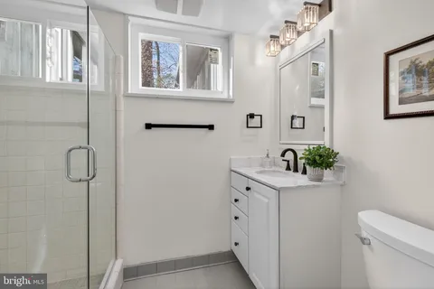 a bathroom with a shower sink vanity and toilet