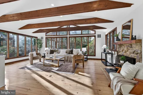 a living room with fireplace furniture and a large window