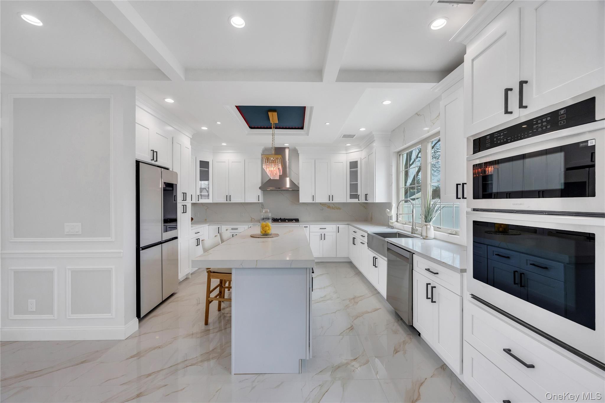 157 4th Street Hicksville, NY 11801 - Photo 8 of 20 Kitchen with a breakfast bar, a sink, beamed ceiling, wall chimney exhaust hood, and appliances with stainless steel finishes