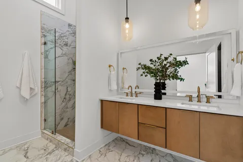 a bathroom with a double vanity sink and shower