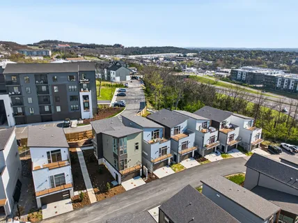 an aerial view of multiple houses with a city street