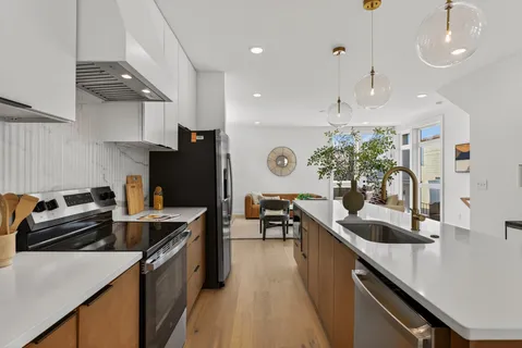 a kitchen with granite countertop a sink a counter top space stove and cabinets