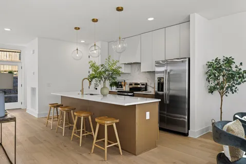 a kitchen with kitchen island a counter space a sink refrigerator and cabinets