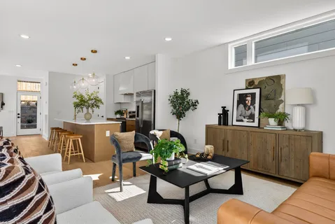 a living room with furniture kitchen view and a window