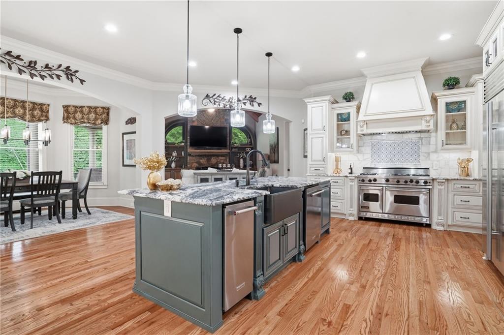 8340 Colonial Place Duluth, GA 30097 - Photo 13 of 74 a kitchen with stainless steel appliances granite countertop a stove and chairs