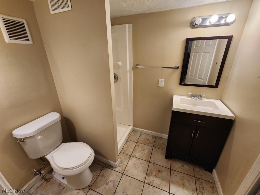 3602 Silsby Road University Heights, OH 44118 - Photo 10 of 19 Bathroom featuring toilet, walk in shower, a textured ceiling, oversized vanity, and tile flooring