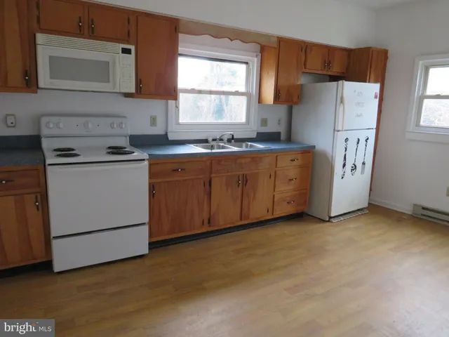 a kitchen with granite countertop cabinets a refrigerator and a sink