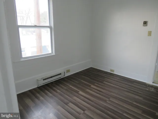 a view of a room with wooden floor and window