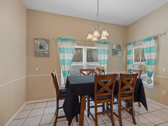 a view of a dining room with furniture a chandelier and wooden floor