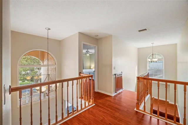 a view of a room with wooden floor fan and windows