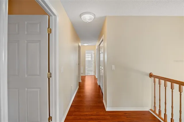 a view of a hallway with wooden floor and staircase